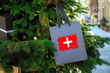 Switzerland flag printed on a Christmas shopping bag. Close up of a shopping bag as a decoration on...