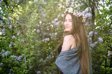 Fototapeta na wymiar Beautiful young sensual girl among spring flowering trees