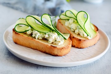 Sandwich with cream cheese and fresh cucumber. Close-up. Vegetarian fitness sandwich with cottage cheese, cucumber and dill, breakfast. English sandwich