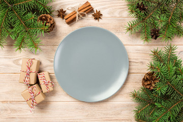 Empty gray matte plate on wooden background with christmas decoration, Round dish. New Year concept