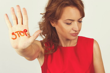 Pretty woman hand stop sign body language enough concept in red dress isolated on white