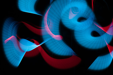 Light painting abstract background. Blue and red light painting photography, long exposure, ripples and swirl against a black background. © Regina