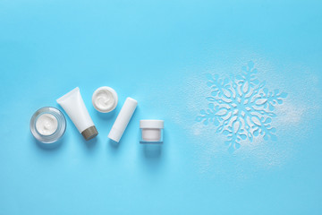 Set of cosmetic products on blue background, flat lay with space for text. Winter care
