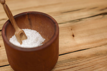 salt in a wooden plate with a wooden spoon