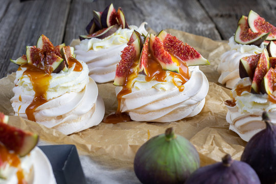 Small figs pavlova with whipped cream and caremel glaze on baking paper - Powered by Adobe