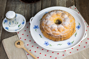 Top view od a Czech traditional marble bundt cake with sugar bowl on old ceramic dining set.