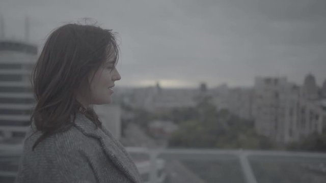Young girl looks at a beautiful view of the city. Slow motion, s-log, ungraded
