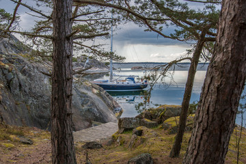 Sailboat at anchor in a lonely bay of Gubboe Kupa Skerry island in the Stockholm skerry gardenm Swedish east coast