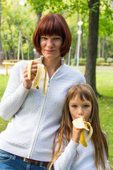 Mother and daughter eating banana