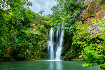 Fototapeta na wymiar Big waterfall falling to pond in the forest