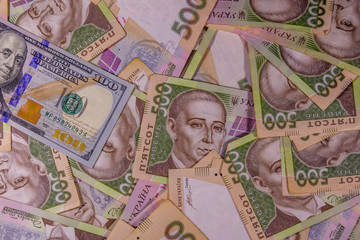 American one hundred dollars banknote on the many ukrainian hryvnas