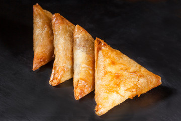 Indian samosas on black background