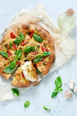 Italian focaccia with tomatoes, pesto sauce, garlic and rosemary. National bread. Copy space