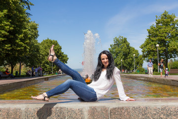Brunette with upward legs on fountain background