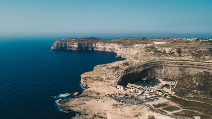 Scenic aerial shot of beautiful bay with rocky cliffs and clear blue water of Mediterranean sea. Sunny summer day. Malta
