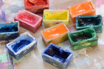 watercolor paints in boxes on painted paper