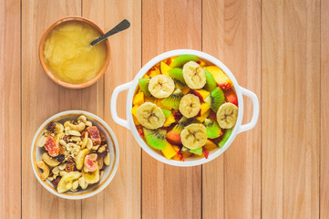 A bowl of fruit, honey and nuts with candied fruits. Top view