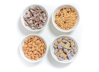 bowls of different cereal on a white background. granola, kashi and cereal chocolate chip cookies. flat lay, top view