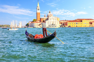 Fototapeta na wymiar A venetian gondolier sailing to San Giorgio Maggiore island