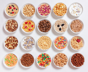 set of different cereals with milk on a white background. 20 bowls with cornflakes, kashi, cereals...