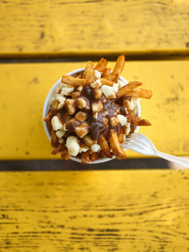 Poutine on a yellow picnic table from above