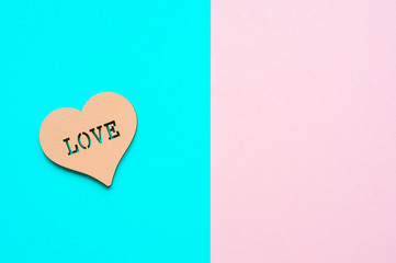 Wooden heart on a pink and blue background, top view for your text
