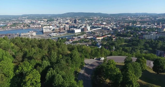 Aerial view and flight over precincts of Oslo city. Compact, bustling downtown with new constructions, roads and streets. Overlook from Ekebergparken, Ekeberg. Norway