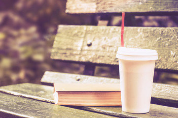Coffee mood. Coffee and book on a wooden bench in the park