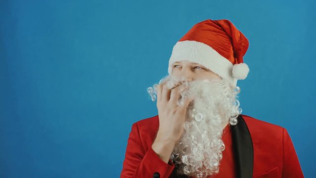 Christmas and New year, wondered man like a Santa thinks and ponders, on blue background