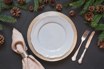 Christmas table setting with silverware and dark evergreen decor. Top view. Holiday Centerpieces.
