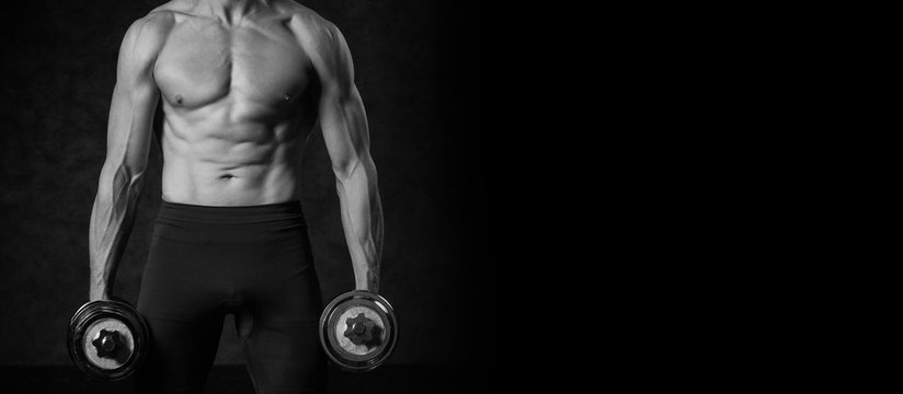 Fitness muscular body on dark background. Photo with copy space for text