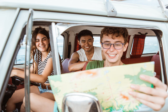 portrait of young people inside car using a map