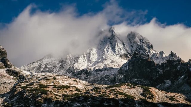 Snowy and cloudy time lapse mountain landscape from Rysy peaks at winter with blue sky on background, Slovakia.