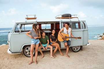 Hipster playing guitar for his friends