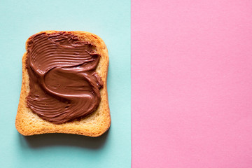 Top view of toasts with chocolate butter on blue pastel and pink pastel background