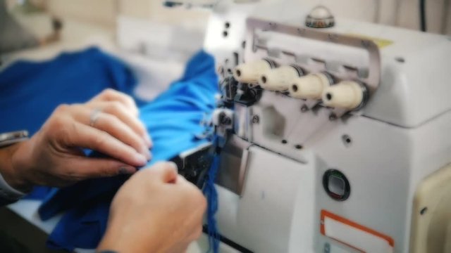 Making clothes. Woman works with cloth on Sewing Machine. Focus on tool