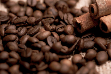 Cafe design, pictures for bars and cafes. Closeup coffee grains on burlap and brown background.