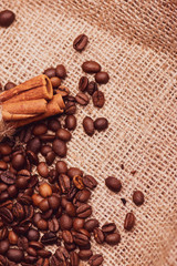 Cafe design, pictures for bars and cafes. Closeup coffee grains on burlap and brown background.