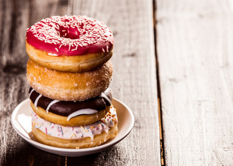 several chocolate and vanilla donuts on a plate. Side view