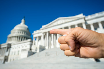 Hand gesturing with finger pointing at the Capitol Building in Washington, DC, USA