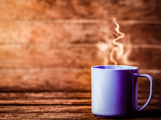 blue cup of coffee on wooden table and background