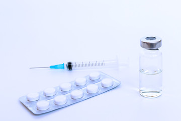 Set of syringe, vial and tablets toned light blue