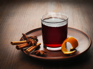 A glass of hot mulled wine in a clay plate