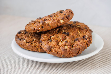 Chocolate chip cookies on rustic dark black background. Stacked chocolate chip cookies on brown napkin. Symbolic image with place for text. Freshly baked. Concept for a tasty snack. Sweet dessert.