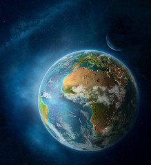 Equatorial Guinea from space on Earth surrounded by space with Moon and Milky Way. Detailed planet surface with city lights and clouds.