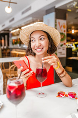 Traveler woman drink sangria and using smartphone in spanish cafe