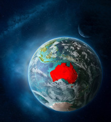 Naklejka na ściany i meble Australia from space on Earth surrounded by space with Moon and Milky Way. Detailed planet surface with city lights and clouds.