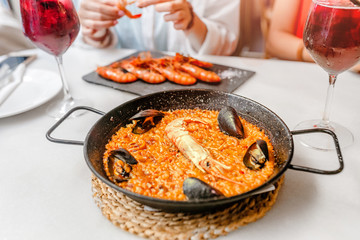 Traditional Spanish paella with seafood and rice on the table in restaurant