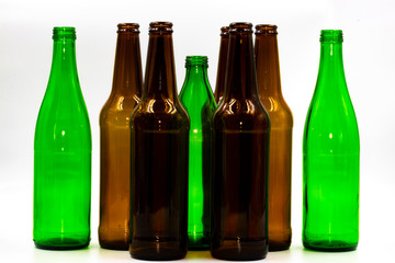Colored empty glass bottles on white background
