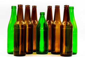 Colored empty glass bottles on white background